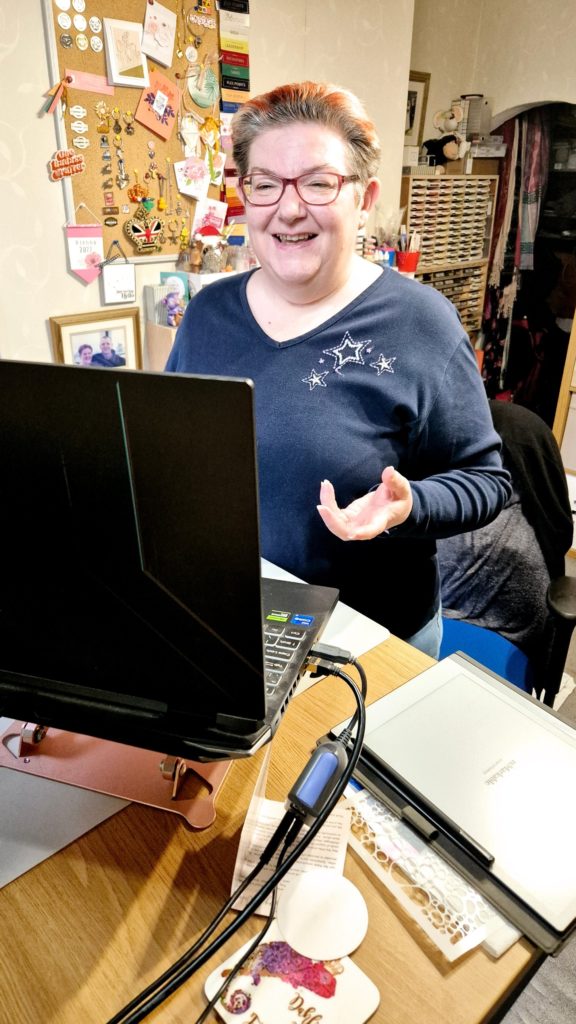 Pip smiling at her laptop in her craft room, teaching an online class